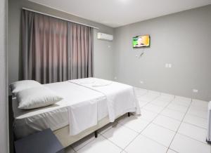 a hotel room with a bed and a tv at GB Hotéis Foz Centro in Foz do Iguaçu