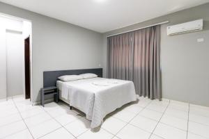 a bedroom with a white bed in a room at GB Hotéis Foz Centro in Foz do Iguaçu