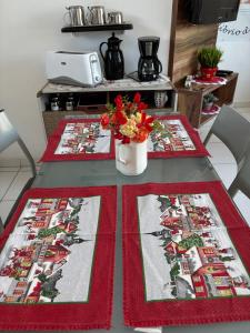 a table with two mats on it with a vase of flowers at Espaço Zen - Equilíbrio da Alma in Guarujá