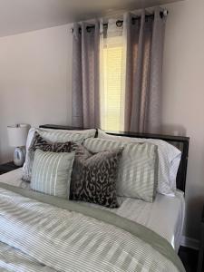 a bedroom with a bed with pillows and a window at Skipper Apt #4 in Rockingham