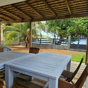 a white table and chairs on a wooden deck at Charmante villa bord de mer les pieds dans l'eau in La Trinité