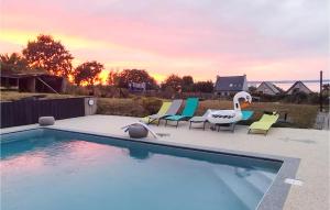 a swimming pool with lounge chairs and a swan at Lovely Home In Lanvéoc in Lanvéoc