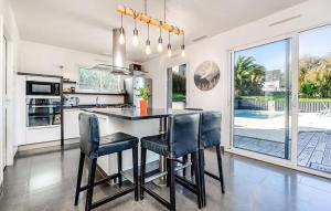 a kitchen and dining room with a table and chairs at Lovely Home In Lanvéoc in Lanvéoc