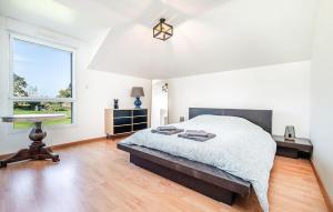 a bedroom with a bed and a desk and a window at Lovely Home In Lanvéoc in Lanvéoc +13 photos