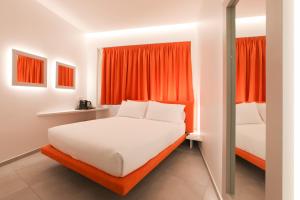 ein Schlafzimmer mit zwei Betten und einem orangefarbenen Fenster in der Unterkunft The Grove in Mailand
