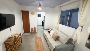 a living room with a couch and a tv at Maramar Beach House in Luis Correia