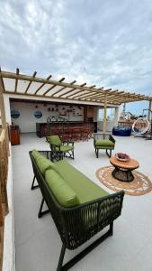 a patio with chairs and a table and a bench at Maramar Beach House in Luis Correia