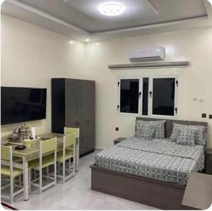 a bedroom with a bed and a table and a desk at ESSERa in Nouakchott