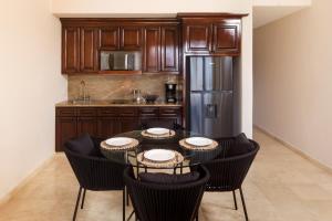 a kitchen with a table with chairs and a refrigerator at Apartamento en Los Cabos - Misiones del Cabo in Cabo San Lucas