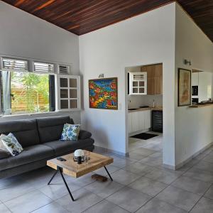 a living room with a couch and a table at Charmante villa bord de mer les pieds dans l'eau in La Trinité