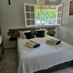 a bedroom with a large white bed with two pillows on it at Charmante villa bord de mer les pieds dans l'eau in La Trinité