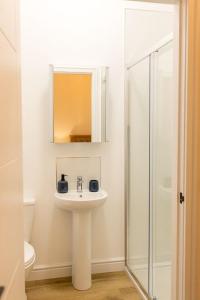 a white bathroom with a sink and a shower at Dale, Burray, Orkney - OR00597F in Burray Village +15 photos