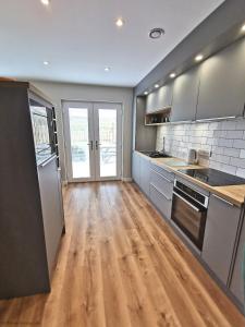 a kitchen with wooden floors and stainless steel appliances at 6 Zetland Road, Kirkwall, Orkney - OR00275F in Kirkwall +10 photos