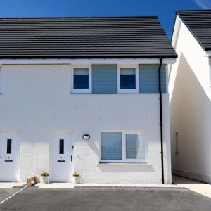 a white house with two windows and a dog at 6 Zetland Road, Kirkwall, Orkney - OR00275F in Kirkwall