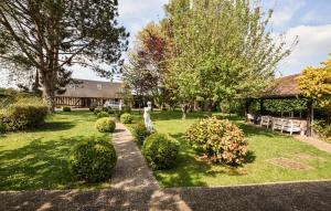 a garden with a pavilion and trees and bushes at Maison Avec Piscine Couverte in Fervaques