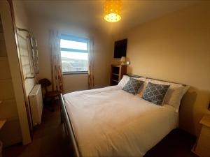 a bedroom with a bed with white sheets and a window at Cunningair, Kirkwall, Orkney - OR00447F in Kirkwall