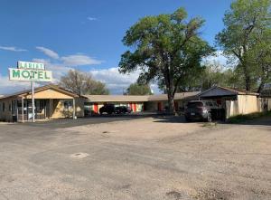 a motel with a car parked in a parking lot at Lariat Motel in Moriarty
