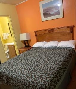 a bedroom with a large bed with two pillows at Lariat Motel in Moriarty