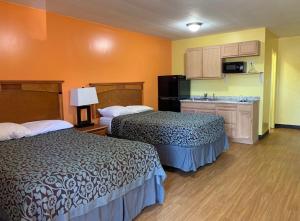a hotel room with two beds and a kitchen at Lariat Motel in Moriarty
