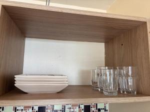 a shelf with bowls and plates and glasses on it at Hotel tropical Manaus suite luxo in Manaus