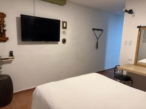 a bedroom with a flat screen tv on the wall at OJAS Compact Studio in San Juan