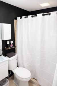 a bathroom with a white shower curtain and a toilet at OJAS Compact Studio in San Juan +12 photos