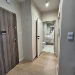 a bathroom with a hallway with a toilet and a sink at Apartment Comfort Premium in Bartoszyce +12 photos