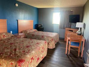a hotel room with two beds and a television at Valley Motel in Atwater