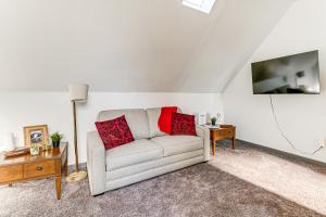 a living room with a couch and a tv at Walkable Location, Historic Setting: Warrenton Apt in Warrenton