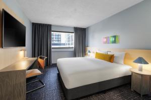 a hotel room with a large bed and a television at lyf on Elizabeth Melbourne in Melbourne +29 photos