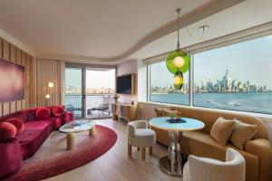 a living room with a red couch and a large window at W Hoboken in Hoboken