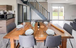 a wooden table with chairs and a bottle of wine at Authentique Ferme En Campagne in Saint-Germer-de-Fly