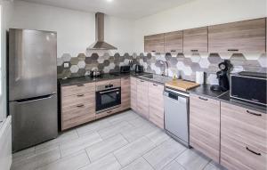 a large kitchen with wooden cabinets and stainless steel appliances at Authentique Ferme En Campagne in Saint-Germer-de-Fly
