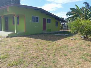 a green house with a yard in front of it at Casa de Malle in Pocrí