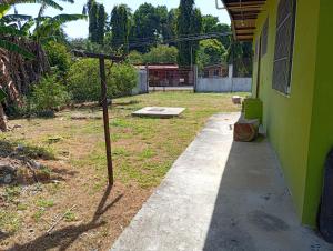 a concrete walkway next to a green building at Casa de Malle in Pocrí +5 photos