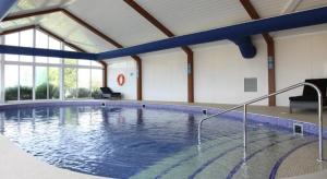 a large swimming pool in a building with a large pool at The Crab Shack in Tywardreath