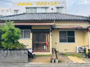 a house with a motorcycle parked in front of it at GROUNDWORK Guesthouse & Lounge in Yugawara
