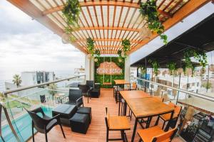a restaurant with tables and chairs on a balcony at Beach House - Besso Beach in Barranca