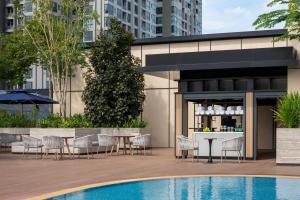 a patio with a table and chairs next to a pool at Sheraton Johor Bahru in Johor Bahru
