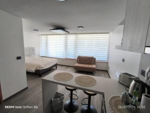 a room with a bed and a kitchen with a table at Departamento Piso 6 in Puerto Montt