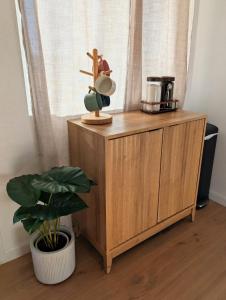 a wooden cabinet with a statue on it next to a plant at Golden Moon Hideaway in Twentynine Palms