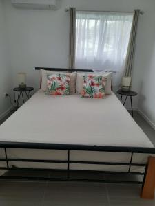 a large bed in a room with two tables at PohatuOkoro in Arorangi
