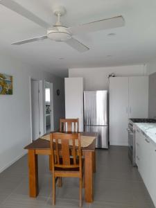 a kitchen with a table and chairs and a refrigerator at PohatuOkoro in Arorangi