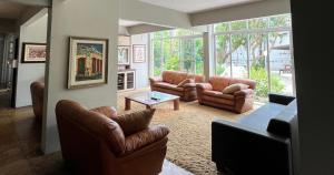 a living room with leather furniture and a large window at HANNA Marina's Palace Hotel in Florianópolis