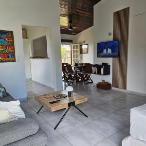 a living room with a couch and a coffee table at Charmante villa bord de mer les pieds dans l'eau in La Trinité