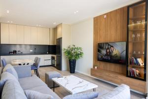 a living room with a couch and a tv at Giselle Escape in Tirana