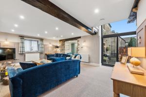 a living room with blue furniture and a large window at The Forge in Castleton