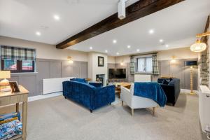a living room with blue couches and a table at The Forge in Castleton