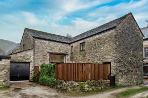 an old stone house with a wooden gate at The Forge in Castleton
