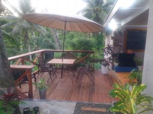 a wooden deck with a table and an umbrella at Master's Homestay in Suva